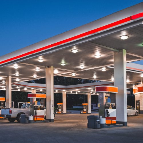 Horizontal shot of a retail gasoline station and convenience store at dusk.